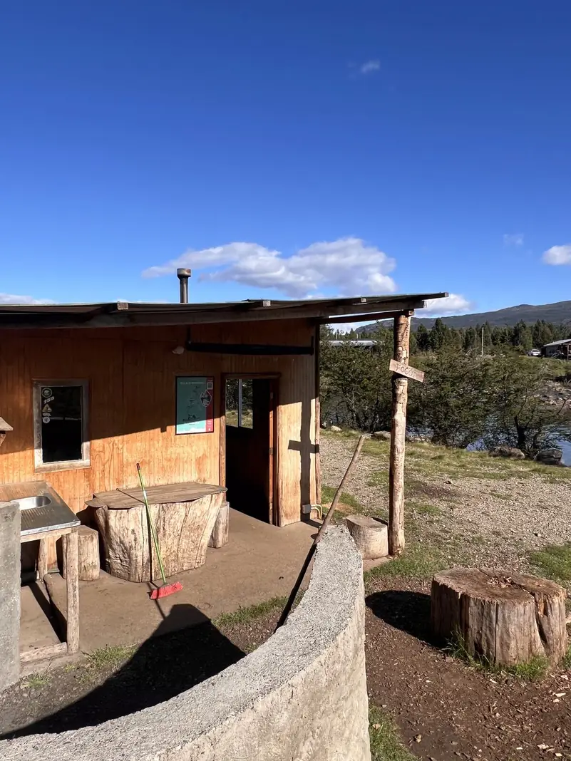 La casa del camping, con su patio y troncos para sentarse