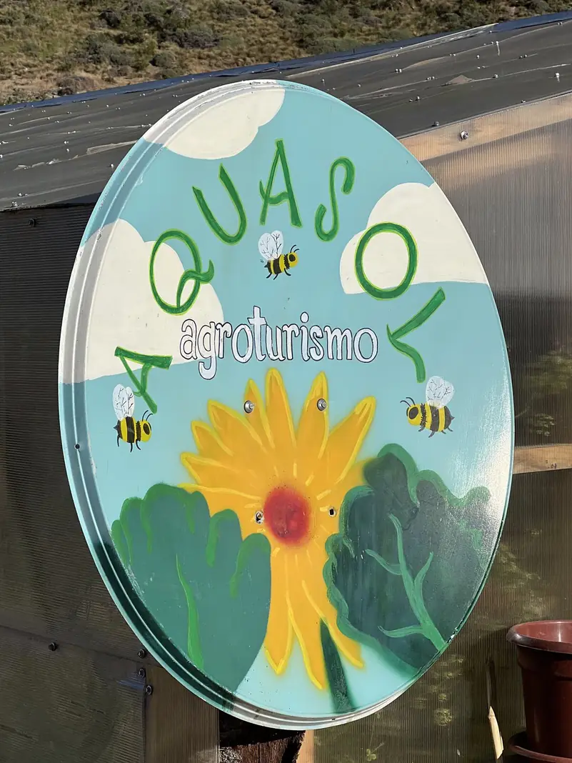 El letrero de Aquasol Agroturismo, con un sol y abejas