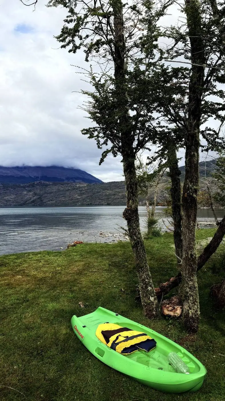 Un kayak verde en el pasto, a la orilla