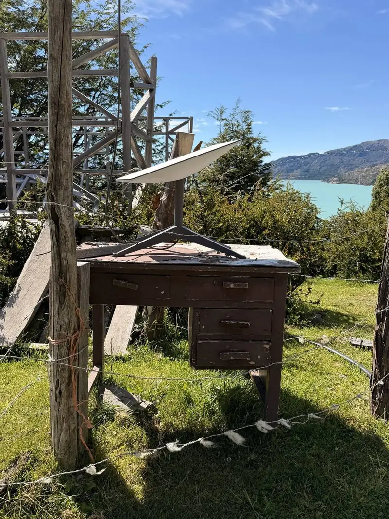 El panel solar sobre un mueble de madera, con el lago detrás