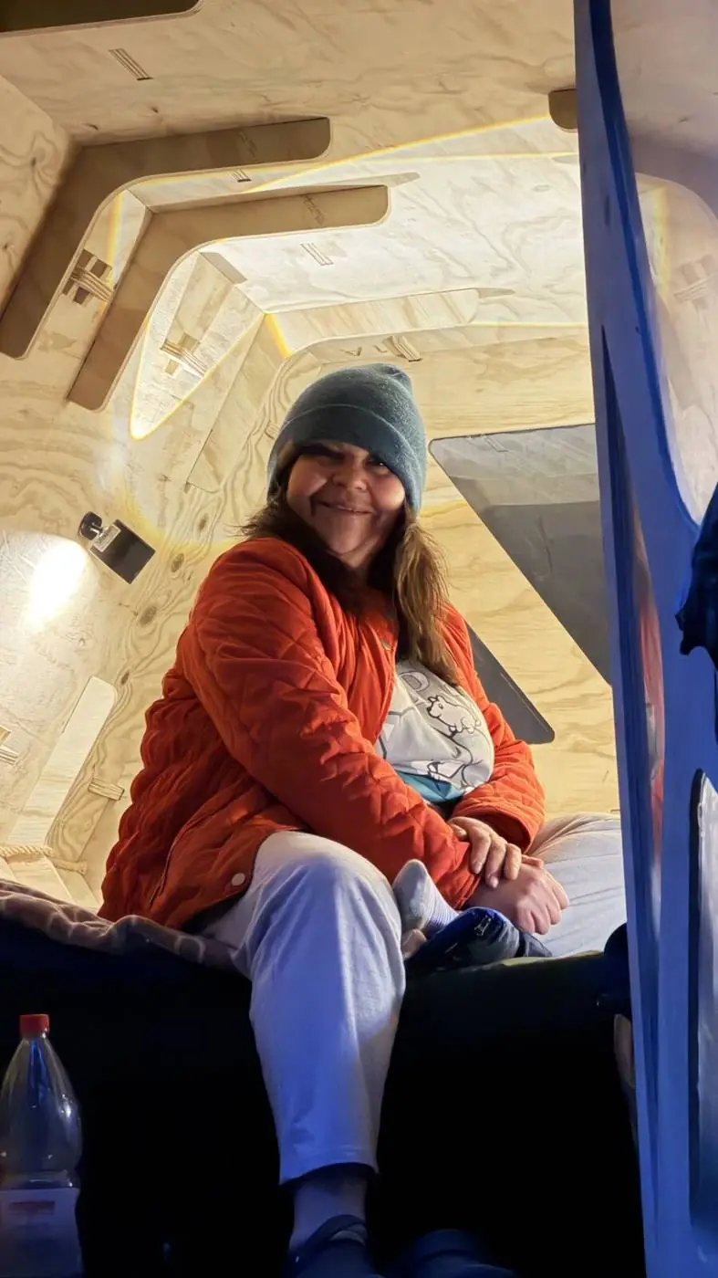 Una viajera sonriendo dentro del refugio