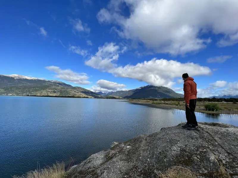 El lago General Carrera en Bahía Murta, con alguien mirando desde una roca