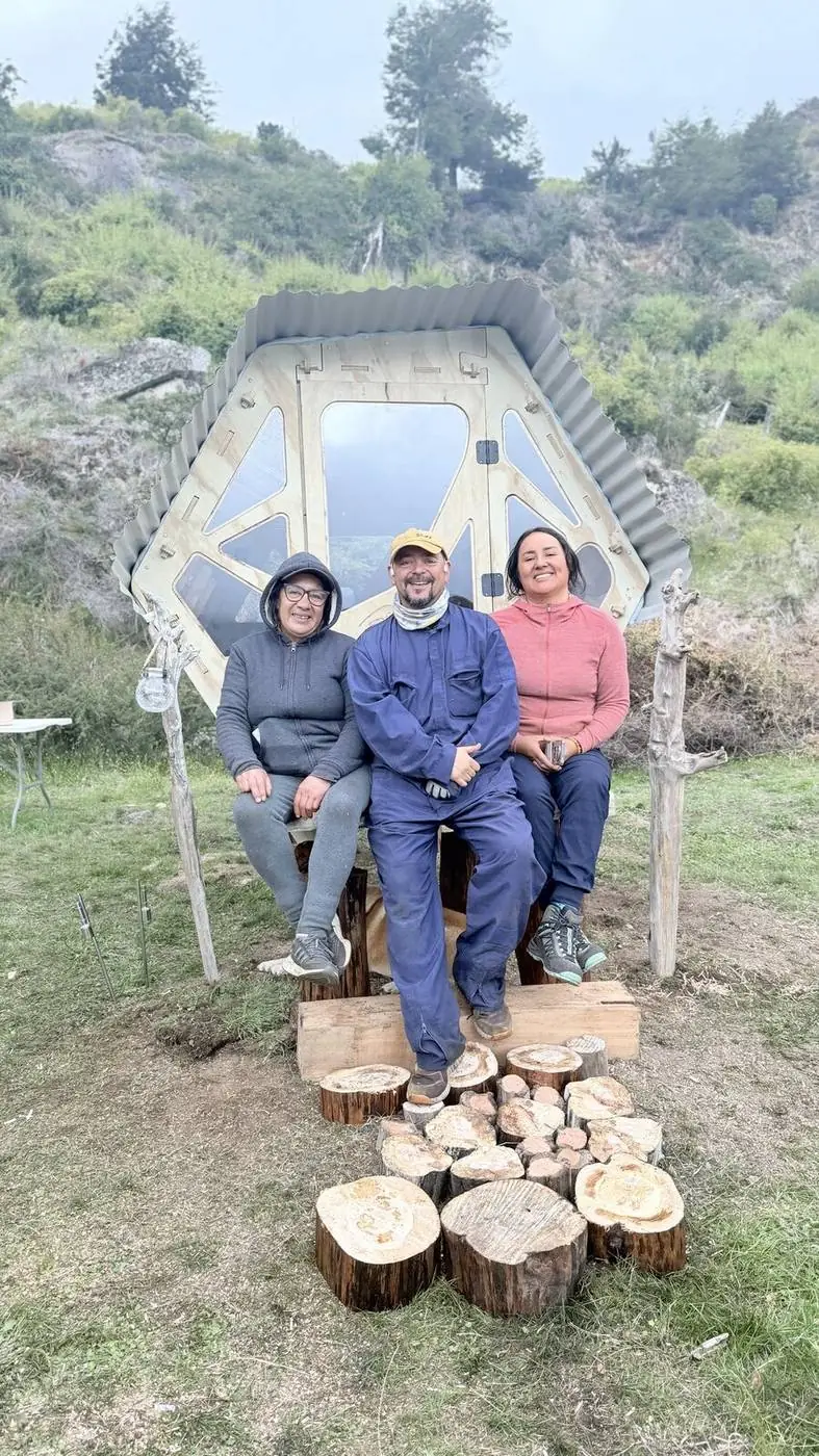 Tres personas sentadas en el refugio recién instalado