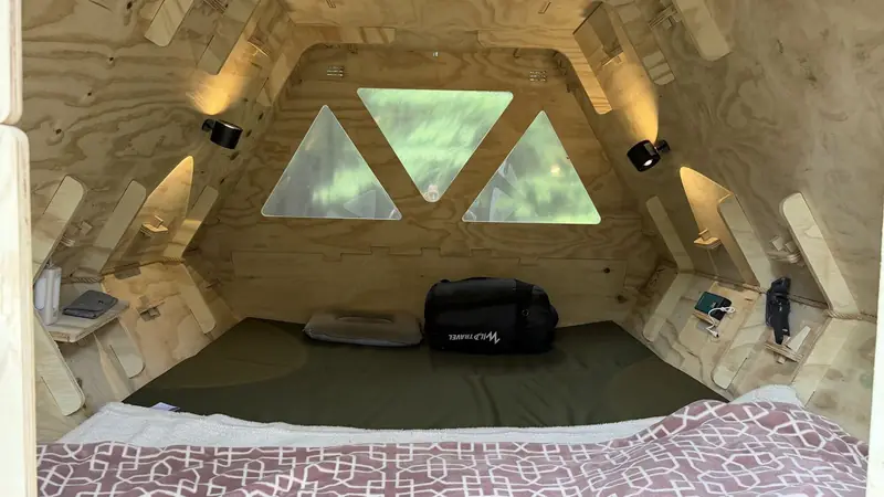 La cama, con la ventana al fondo