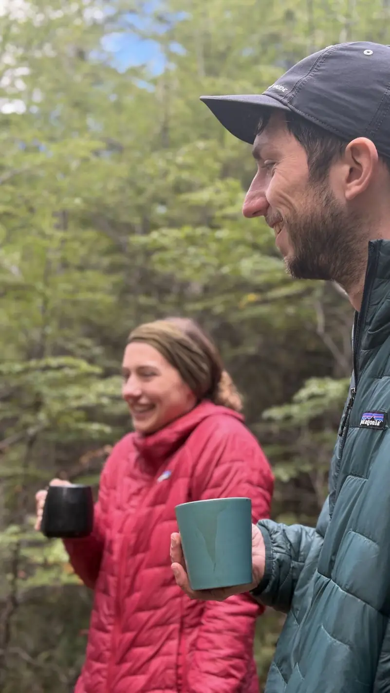 Dos personas con café en la mañana, junto al refugio
