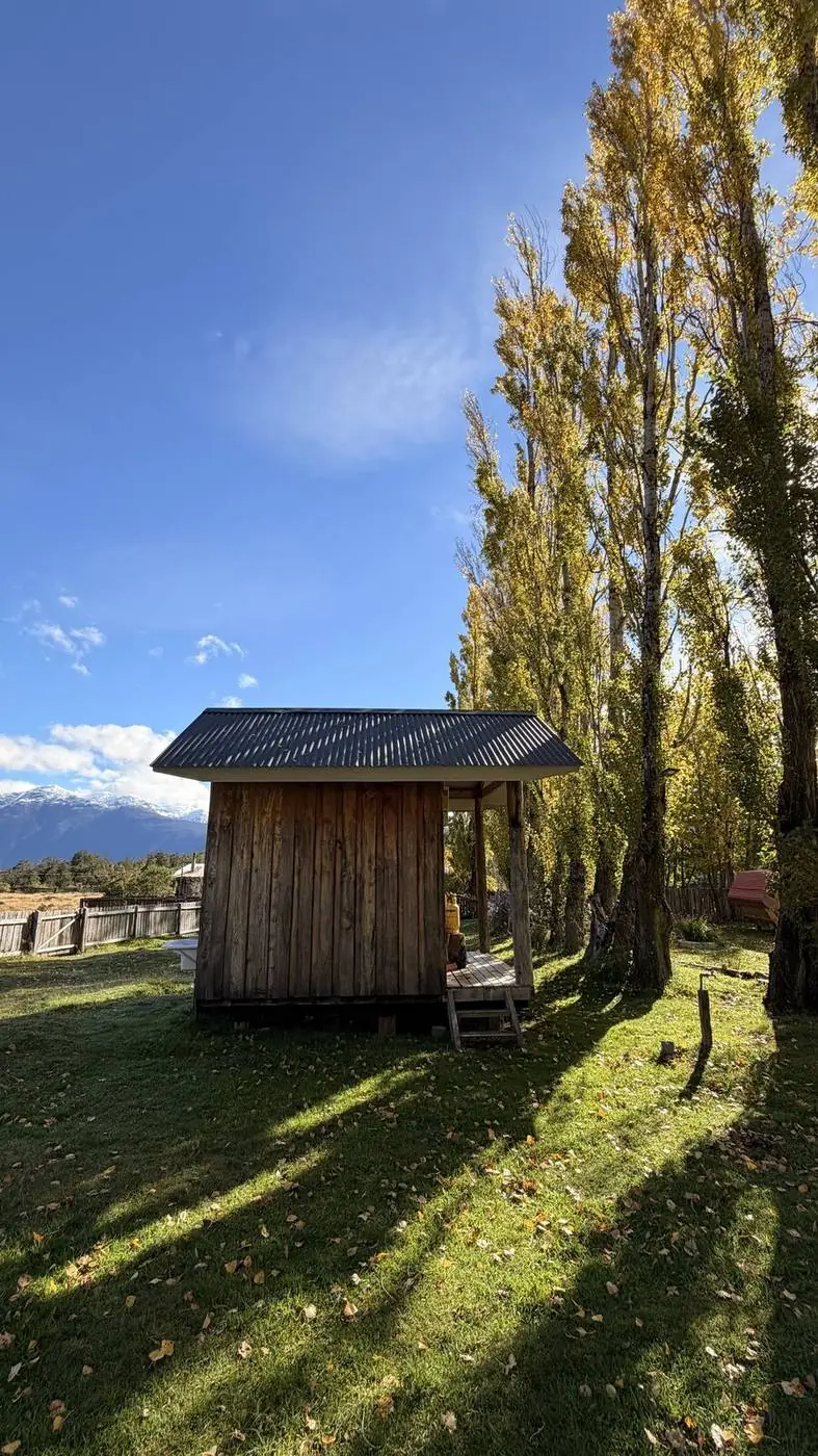 Una casita de madera bajo las alamedas de otoño
