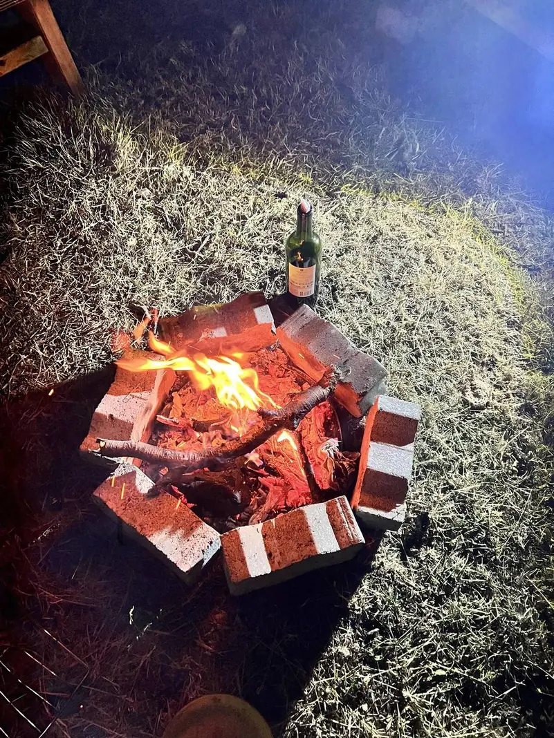 Un brasero encendido de noche en el camping